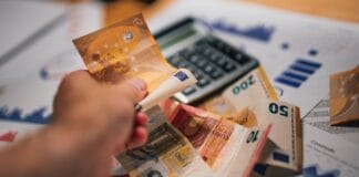 Książki rozwojowe na prezent: dobór tematu do charakteru Banknoty euro na dokumentach finansowych obok kalkulatora