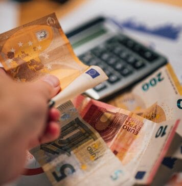 Banknoty euro na dokumentach finansowych obok kalkulatora