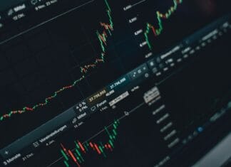 Wojna a gospodarka jak konflikty zbrojne zmieniają wydatki publiczne inflację i oczekiwania inwestorów Zbliżenie na ekran giełdowy z wykresami wzrostu i notowaniami